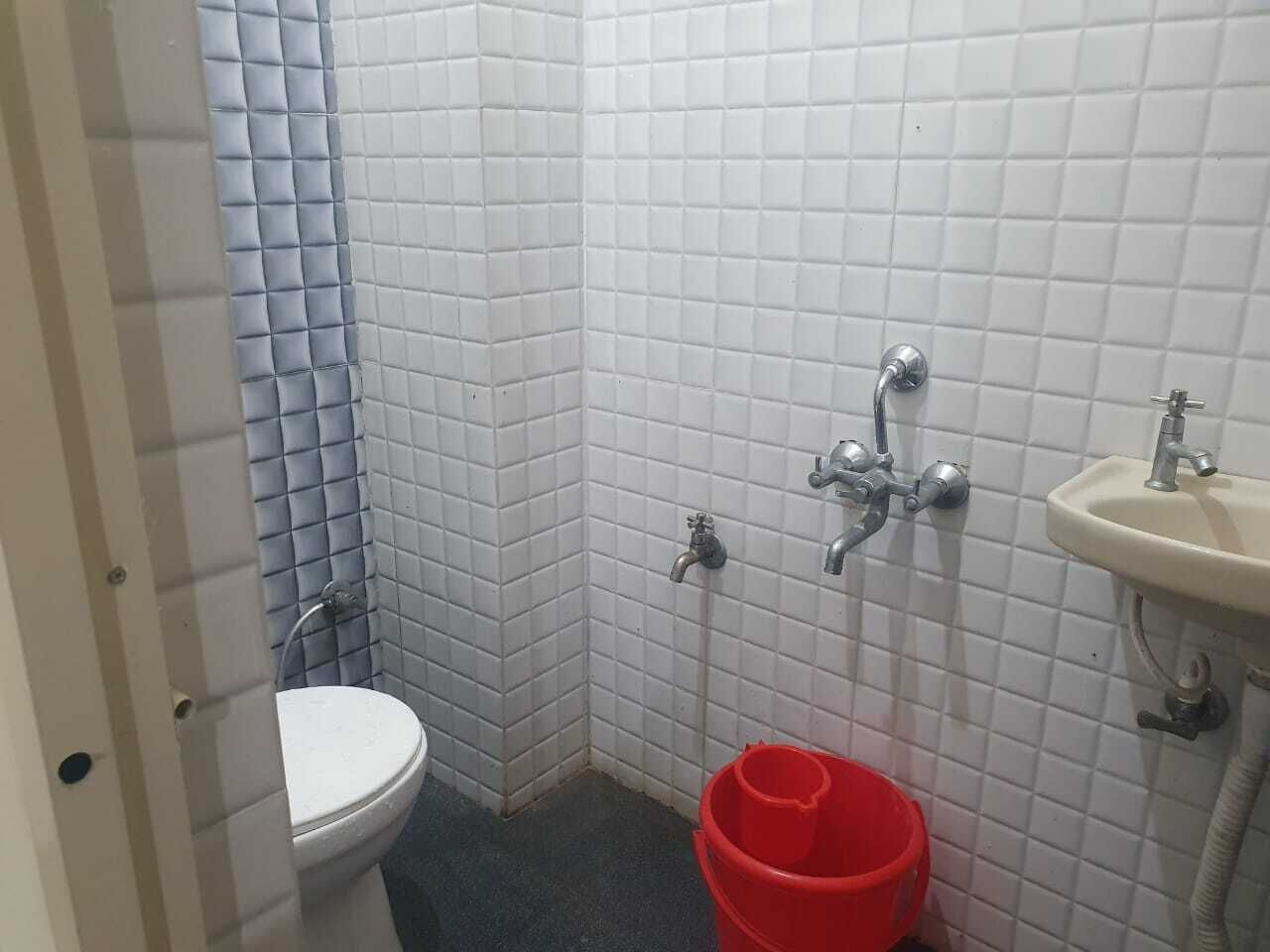 Un bany petit amb vàter, rentapel i zona de dutxa.