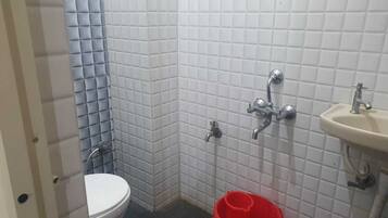 Un bany petit amb vàter, rentapel i zona de dutxa.