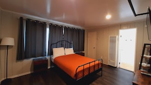 A bedroom with a bed, a bedside table, a lamp, a wardrobe, and a radiator.
