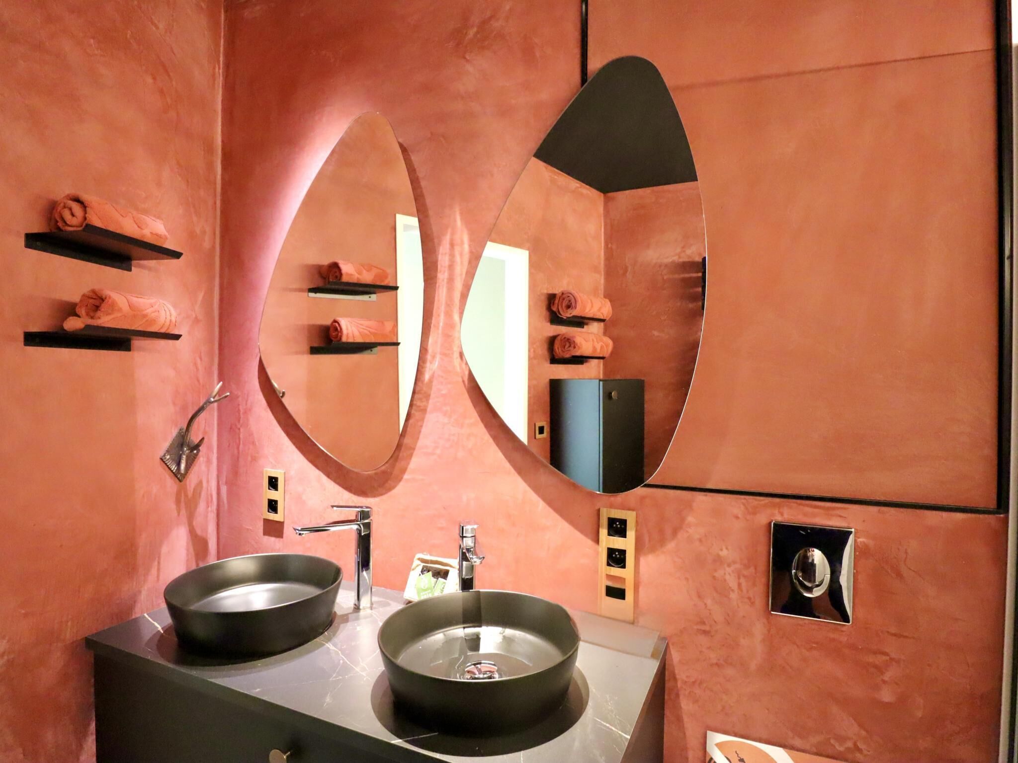 A bathroom with two sinks, a large mirror, and a towel rack.