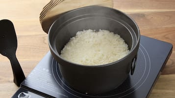 A pot of white rice on an induction cooktop.