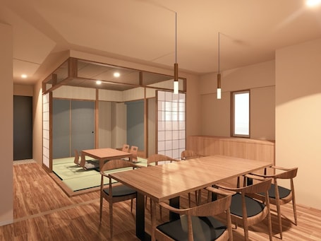 A room with a wooden dining table, chairs, a low partition wall, and a sliding door.