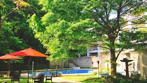 Ein Außenbereich mit Pool, Stühlen und Sonnenschirmen.