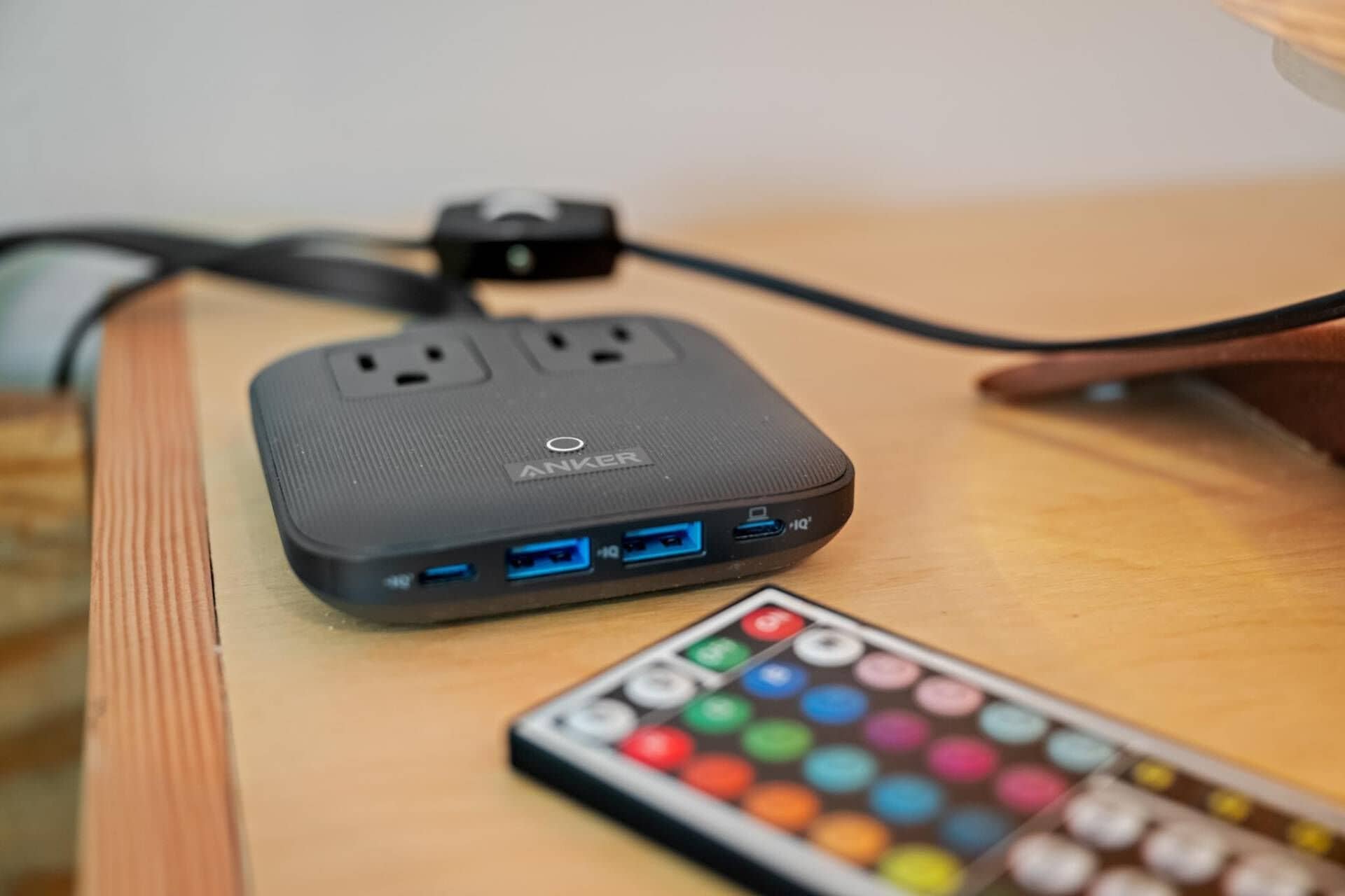 A portable power bank with multiple USB ports and a power outlet on a wooden surface.