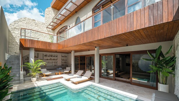 Una casa moderna con piscina, terrazza in legno e ampie finestre.