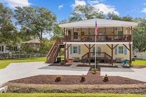 A two-story building with a balcony, a flag, and a small outdoor seating area. - *20% Off New Summer 2026 Bookings* (Murrells Inlet)