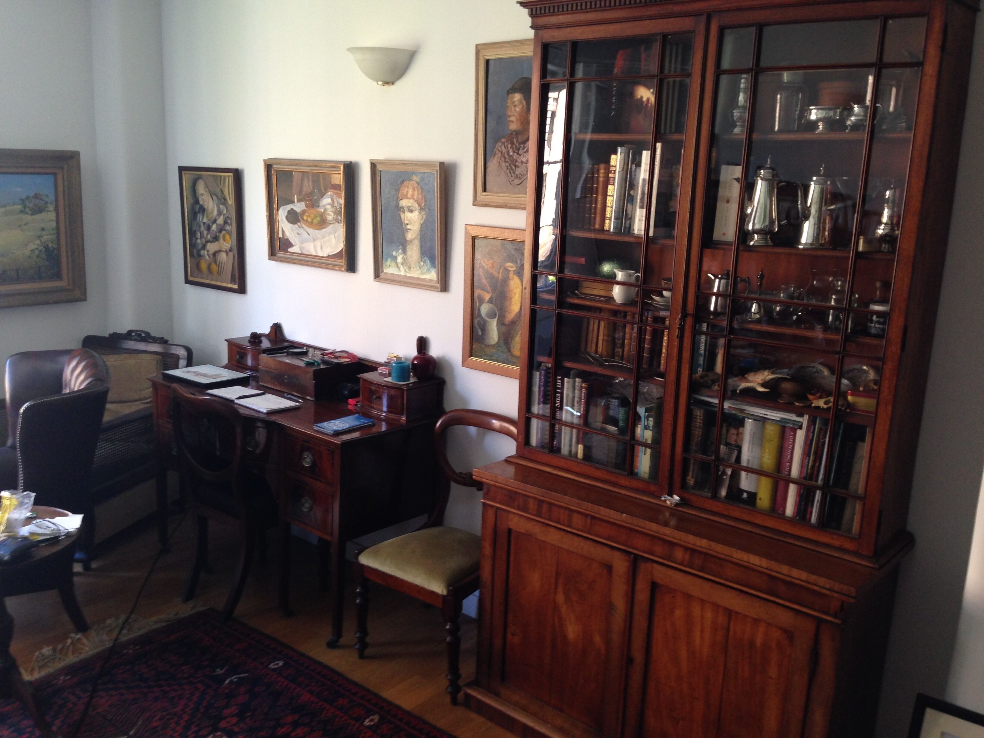 Una biblioteca tradicional con estanterías de madera, un escritorio y sillas.