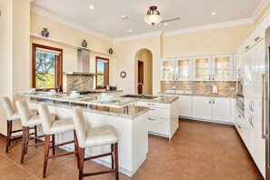 A spacious kitchen with a large island, white cabinetry, and a modern design.