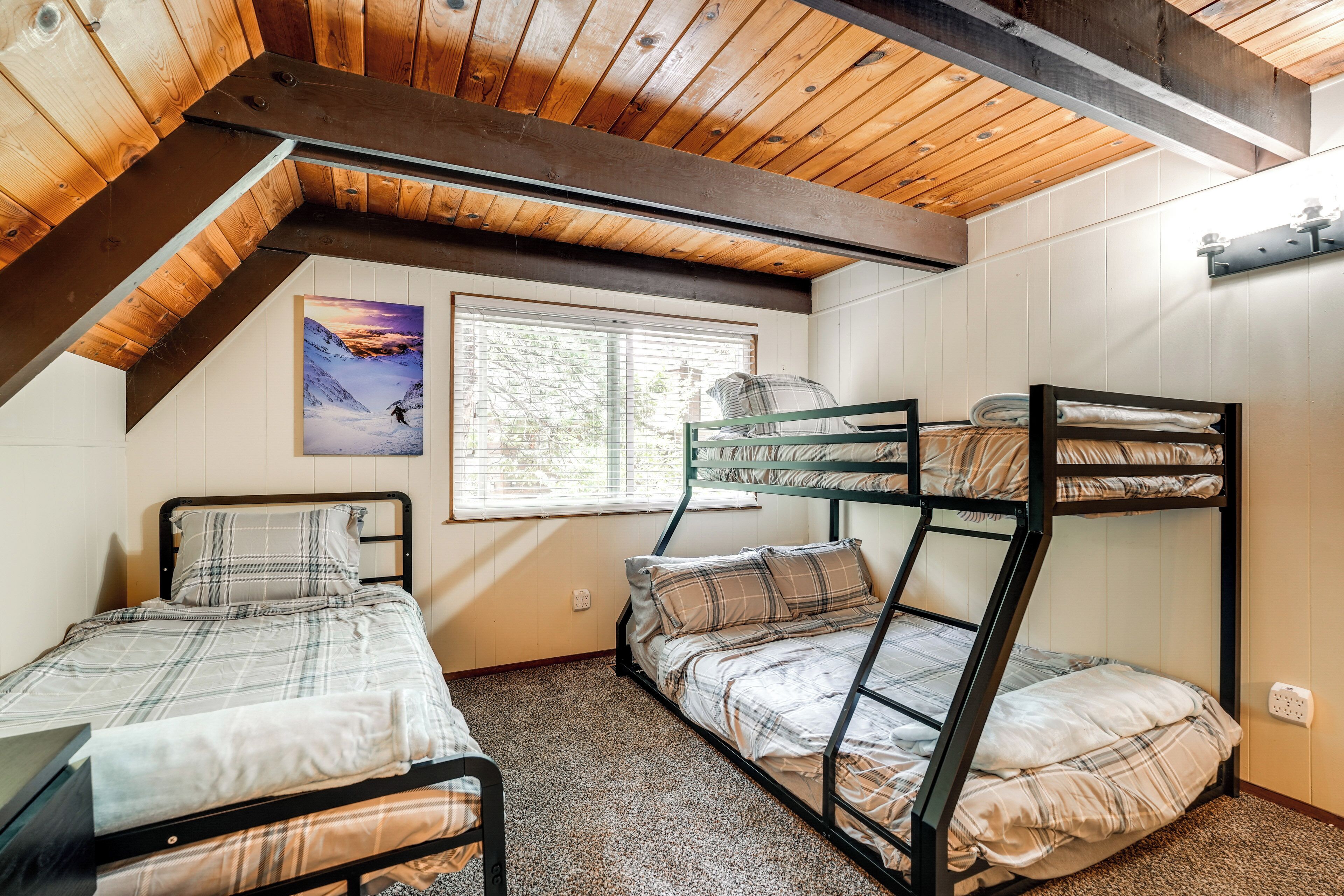 Quarto de dormitório com duas camas beliche, uma janela com cortinas e um quadro na parede.