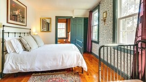 Une chambre à coucher avec un lit, une chaise, un tapis et une porte.