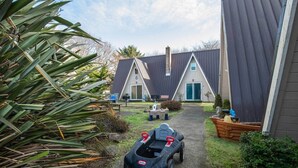 A pathway leading to a row of A-frame cabins with a toy car in the foreground. - Enchanted Forest 2-Story Villa (Ocean Shores)