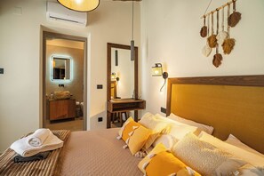 Ein Hotelzimmer mit einem Bett, einem Nachttisch mit Lampe, einem Spiegel und einer Wandleuchte.