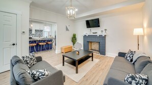 Een moderne woonkamer met een zithoek, een salontafel en een open haard.