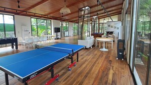 Ein geräumiger Innenbereich mit Tischtennisplatte, Sitzgelegenheiten und Billardtisch.