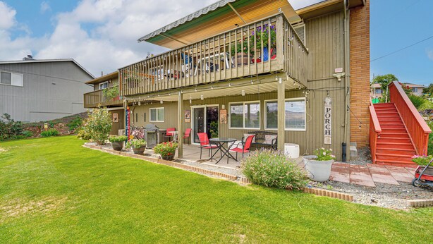 A two-story building with a balcony, outdoor seating area, and a red staircase.