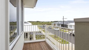 Ein Balkon mit Blick auf ein Wohngebiet, darunter Häuser und eine Straße.