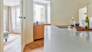 Una cocina moderna con un mueble de madera, una isla grande y vistas de la ciudad a través de un ventanal.