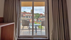 Una habitación con puerta corrediza de vidrio que da a un patio exterior con mesa y sillas.