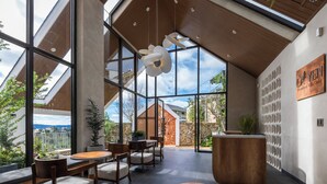 Un intérieur moderne avec de grandes fenêtres, des meubles en bois et une vue sur l’extérieur.