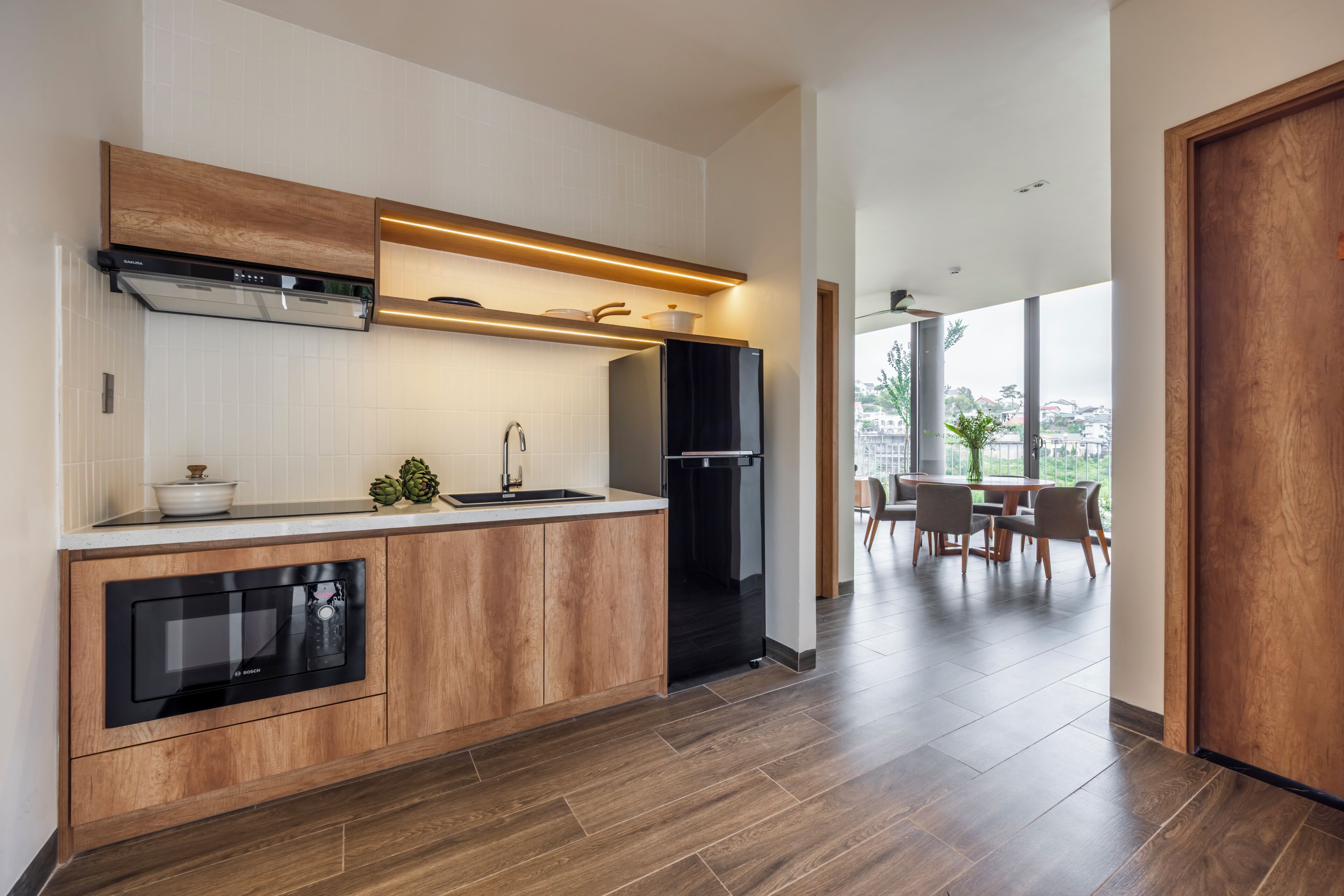 Una cucina moderna con elettrodomestici integrati, un piano di lavoro in legno e un'area pranzo con vista.