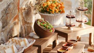 A wooden table with a salad bowl, dessert trays, and small bowls with spoons.