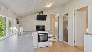 A modern kitchen with white cabinetry, a built-in oven, a microwave, and a stainless steel refrigerator.