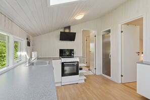 A modern kitchen with white cabinetry, a built-in oven, a microwave, and a stainless steel refrigerator.