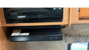 A compact kitchen with a black stove, a built-in oven, a microwave, and a small sink. - Branson Glamping - all set up for you (Branson)