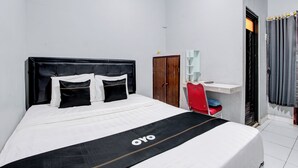 A bedroom with a bed, a wardrobe, a desk, and a chair. - OYO 3220 Samudra Guesthouse (Depok)