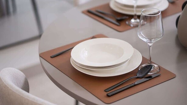 A dining table set with plates, cutlery, and a wine glass. - Dubai Luxury Apartment w/ Pool & Gym, Near Cafes (Dubai)