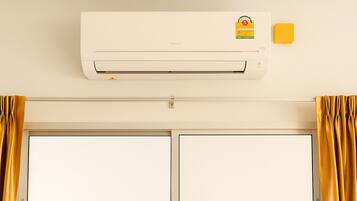 A room with a white air conditioning unit, a door with a handle, and yellow curtains.