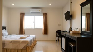 Une chambre d’hôtel équipée d’un lit, d’un bureau, d’une chaise, d’une télévision et d’un appareil de climatisation.