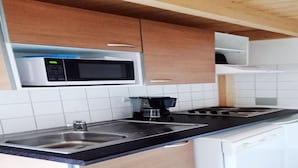 A compact kitchen with a microwave, coffee maker, sink, and dishwasher. - Apartment on Ile D'oleron Near the Beach (Saint-Georges-d'Oleron)