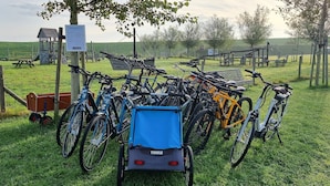 Een fietsenparkeerplaats met een aanhanger en een bord.