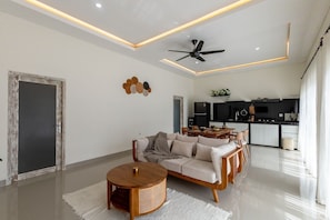 Una sala de estar moderna con sofá, mesa de centro y comedor.