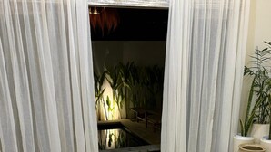 A modern living room with a beige sofa, a wooden coffee table, and a small indoor water feature. - Alinko Villa - 2BR Villa in Seminyak (Seminyak)