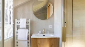 A bathroom with a white sink, a mirror, and a towel rack.
