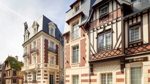 A row of traditional European buildings with distinct architectural styles, including timber framing and brickwork. - Villa Léa, l’écrin du Fer à Cheval (Trouville-sur-Mer)