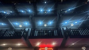A multi-story building with balconies, a sign for 'CHULAH THE KITCHEN,' and a list of cuisines including Indian, Chinese, South Indian, Continental, and Chaat. - Kalptaru The Kumaun retreat (Sukha)