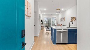 A modern kitchen with a central island, a built-in dishwasher, and a blue accent wall.