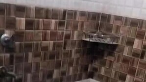 Ein Badezimmer mit gefliestem Rückspritzschutz, einem Waschbecken und einer Toilette.