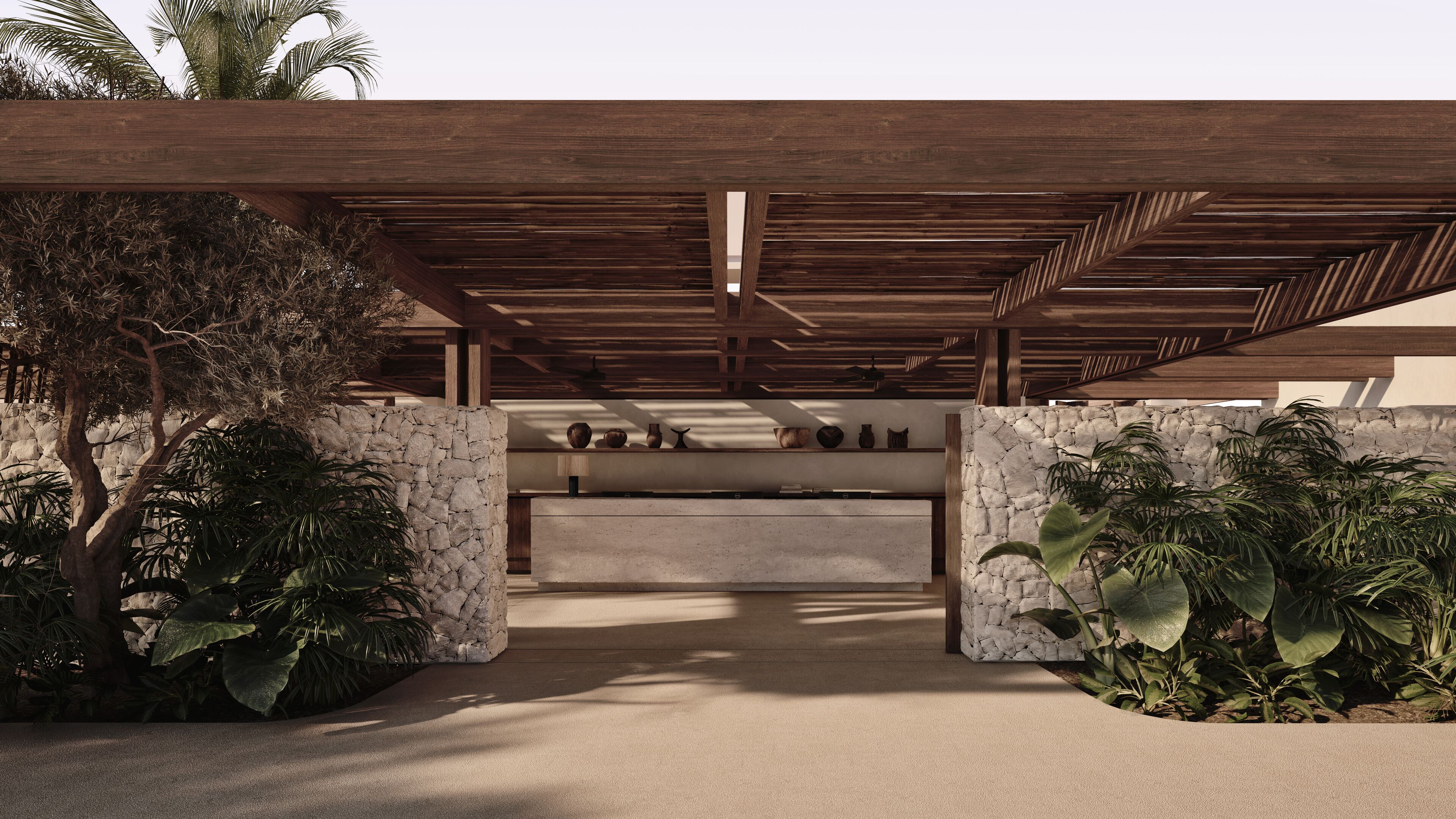 A covered outdoor area with stone walls, a concrete bench, and various decorative items.