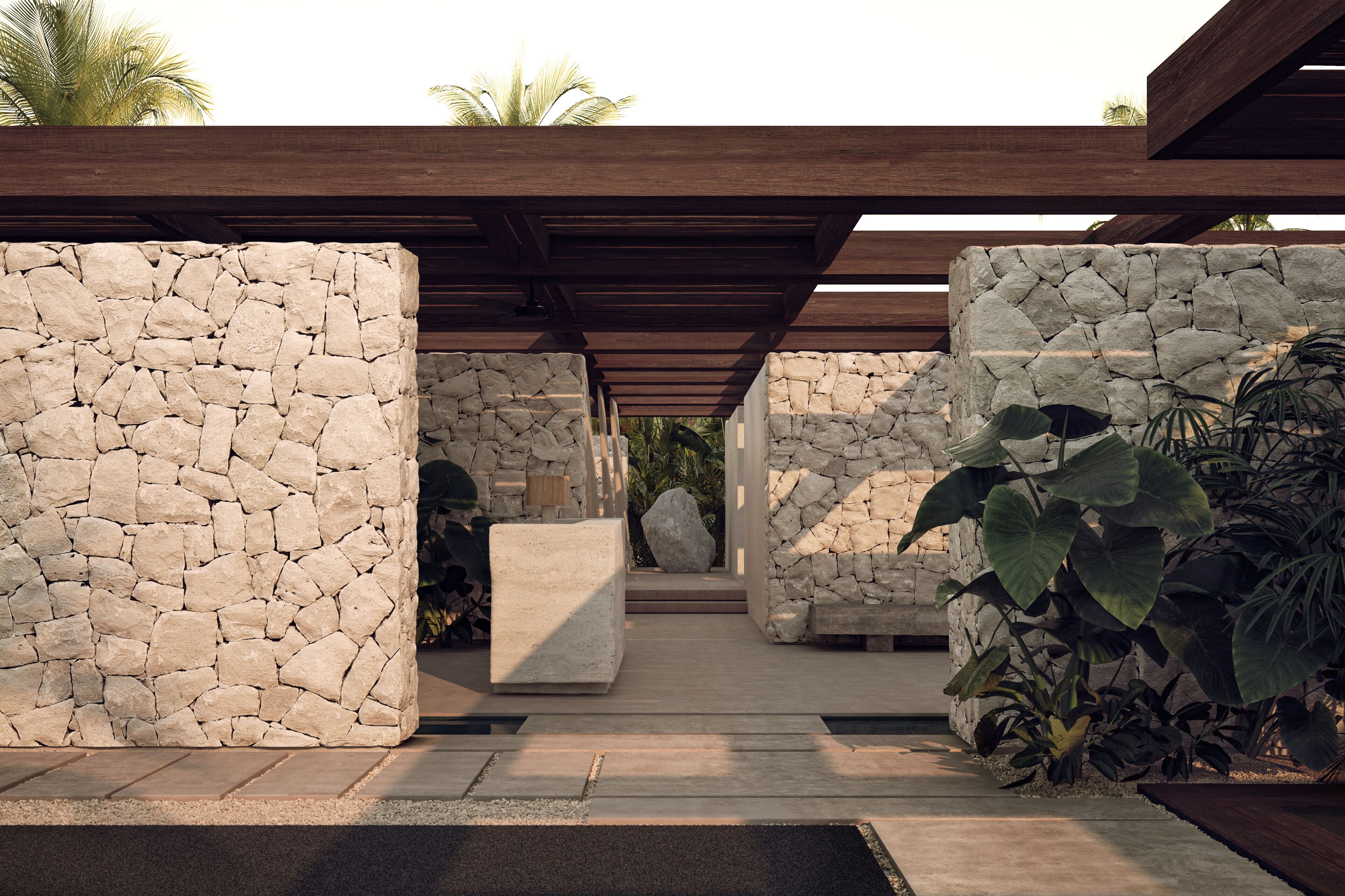 Une structure en pierre avec une pergola en bois, un bloc de béton et des plantes tropicales.