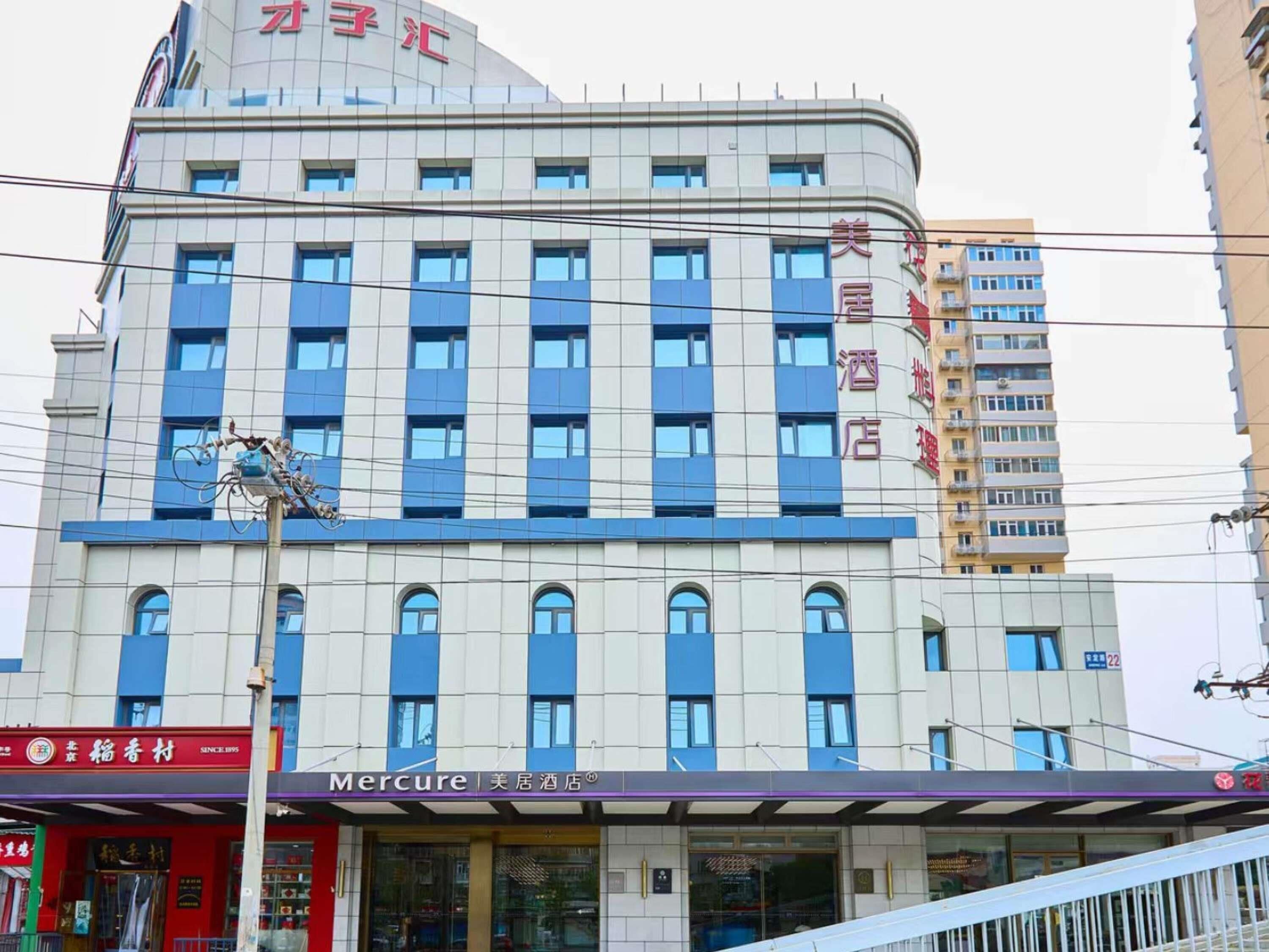 A multi-story hotel with a modern design, featuring a prominent 'Mercure' sign at the ground level.