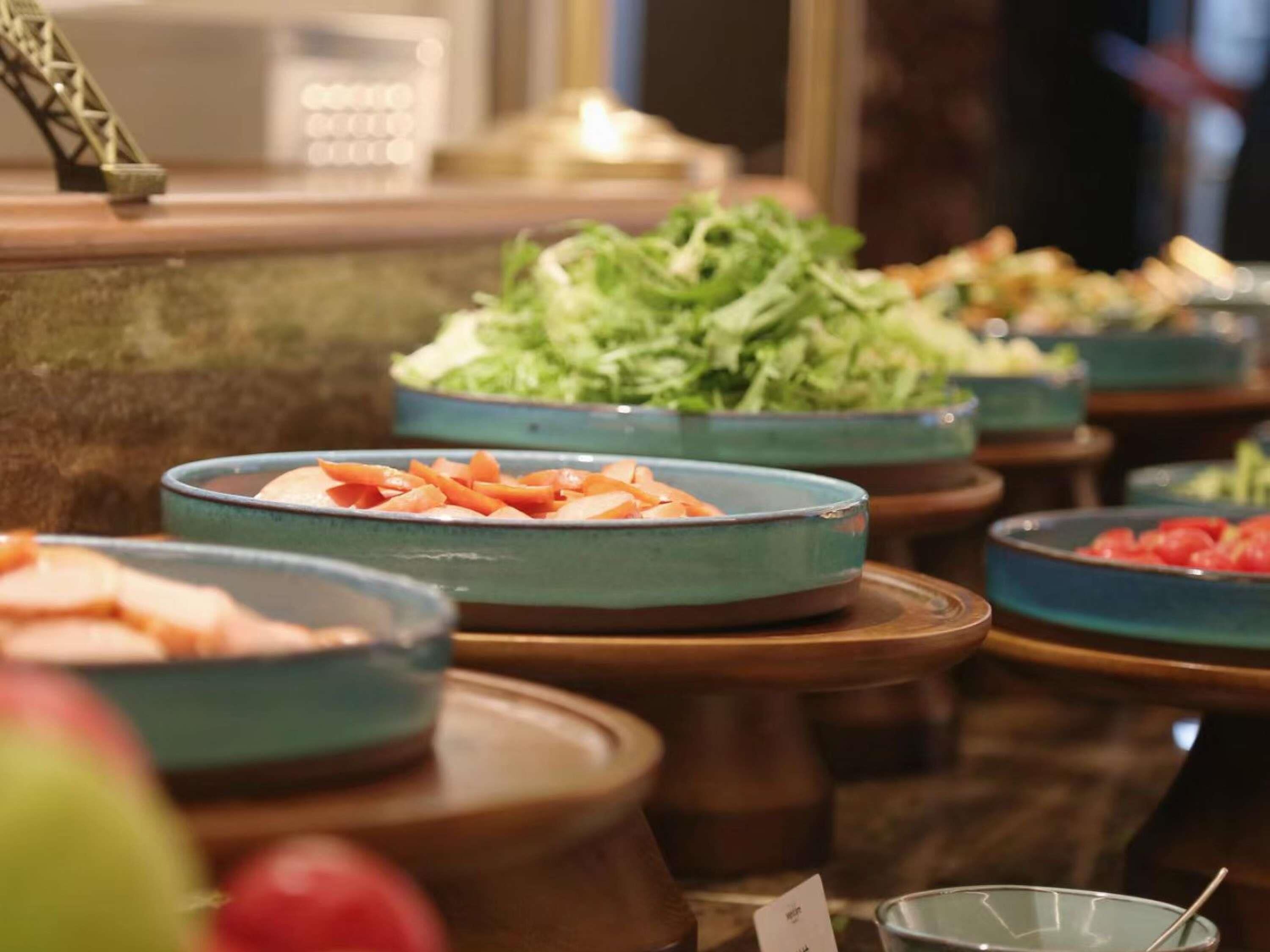 A buffet with various food items including salads and fruits.