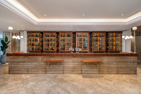 Un’area bar con pavimento in marmo, bancone in legno e diverse scaffaliere.