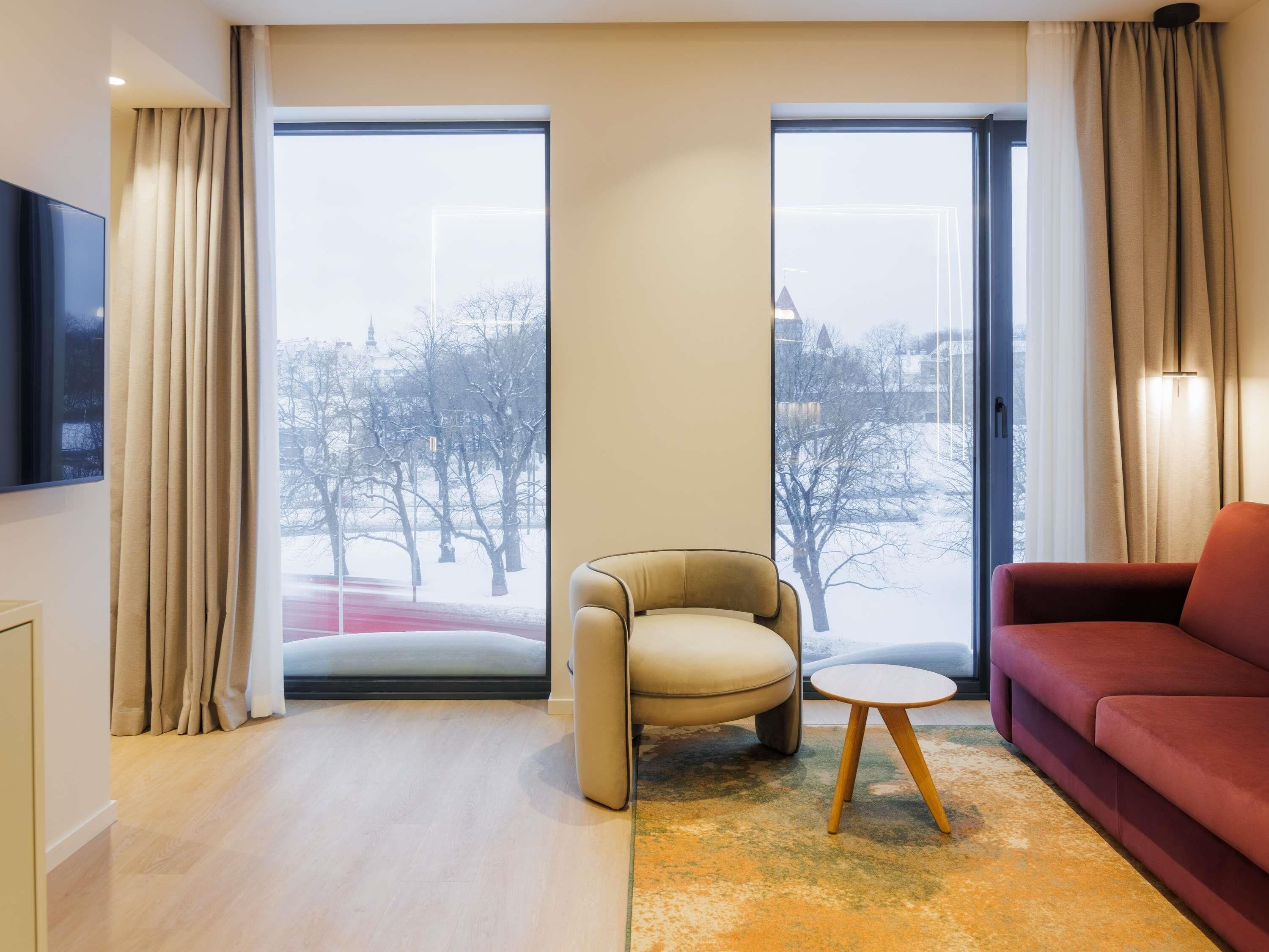 A modern living room with a sofa, armchair, and a small table.