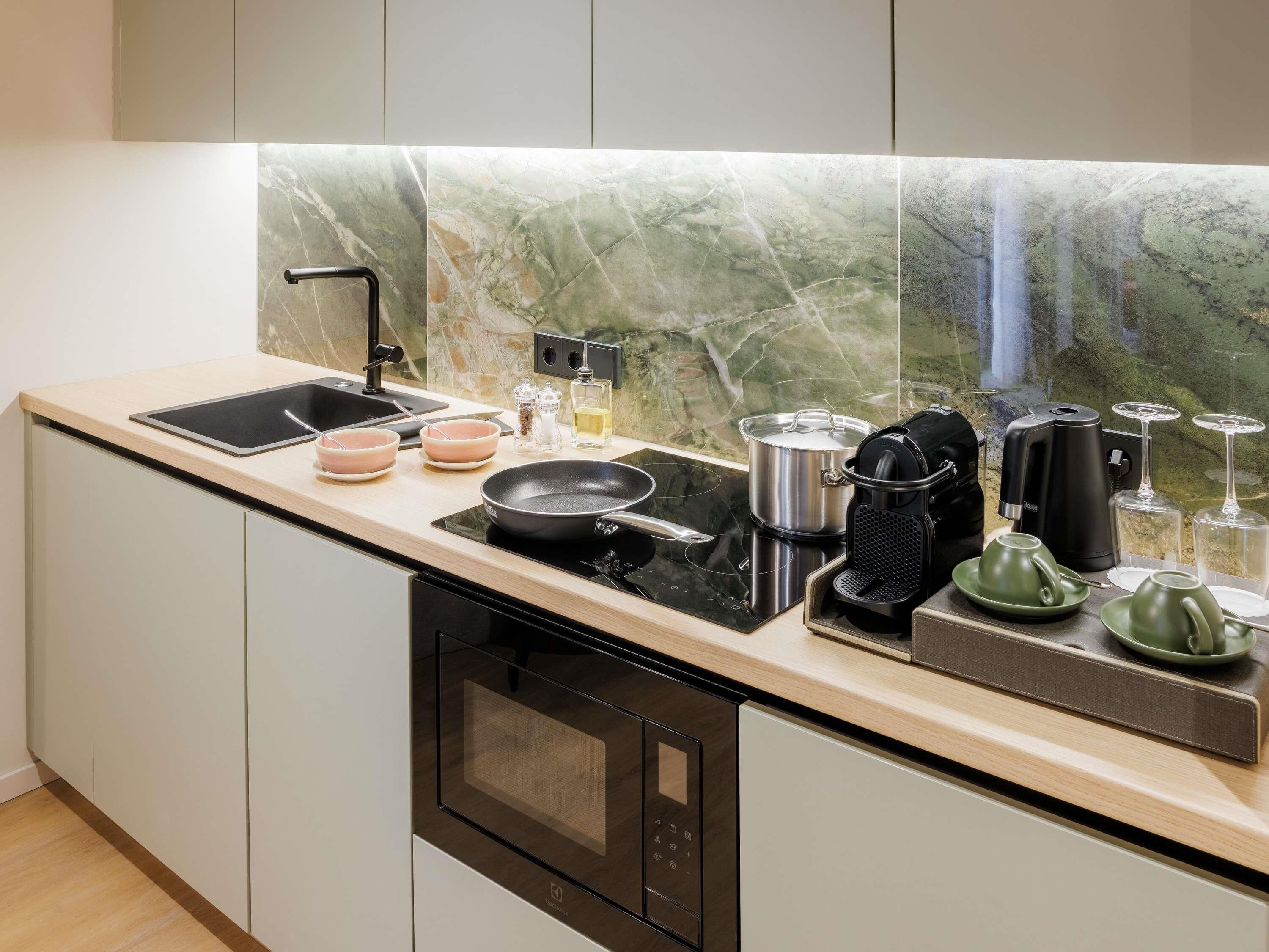 A modern kitchen with a sink, stove, and various appliances.