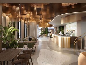 Een moderne hotel lobby met een gebogen receptiebalie, zithoeken en een trap.