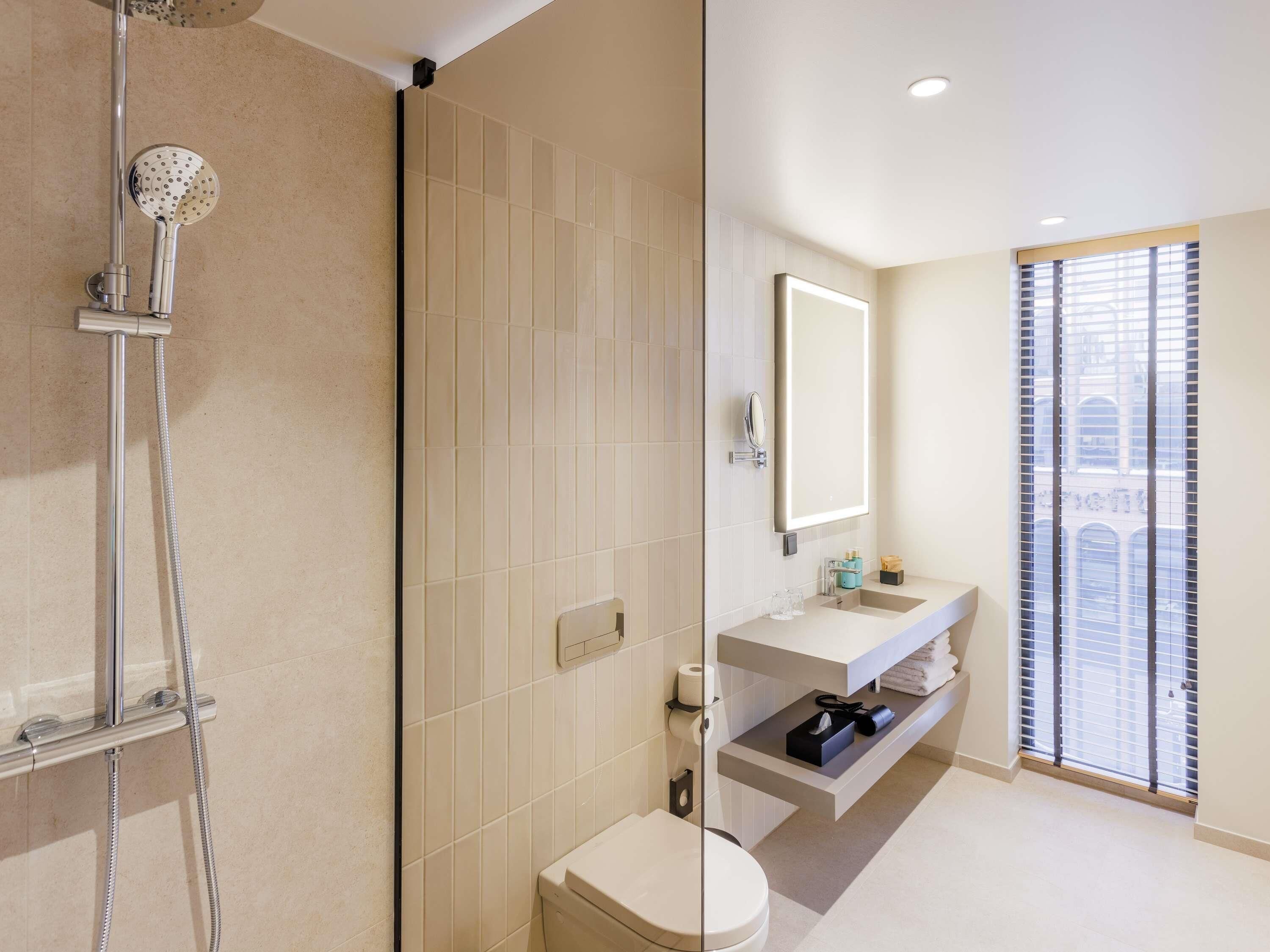 Un baño moderno con ducha, inodoro y lavamanos.